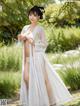 A woman in a white kimono is posing for a picture.