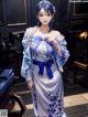 A woman in a blue and white kimono standing in a room.