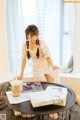 A woman sitting at a table with a cup of coffee.