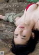 A woman in a red bikini laying on a rock.