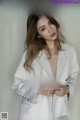 A woman in a white suit posing for a magazine cover.