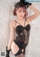 A woman in a black lingerie posing for the camera.