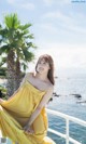 A woman in a yellow dress sitting on a boat.