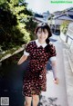 A woman in a red and black dress walking down a street.